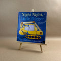 Children's book titled 'Night Night, Little Digger' on a small easel against a beige background