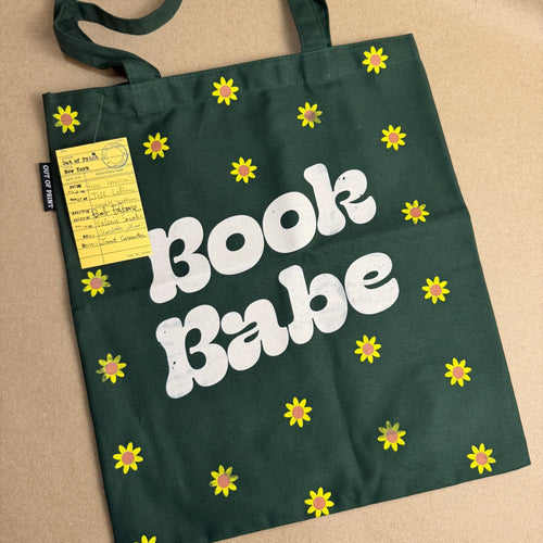 Green tote bag with 'Book Babe' text and yellow daisies, perfect for book lovers and cozy reads.