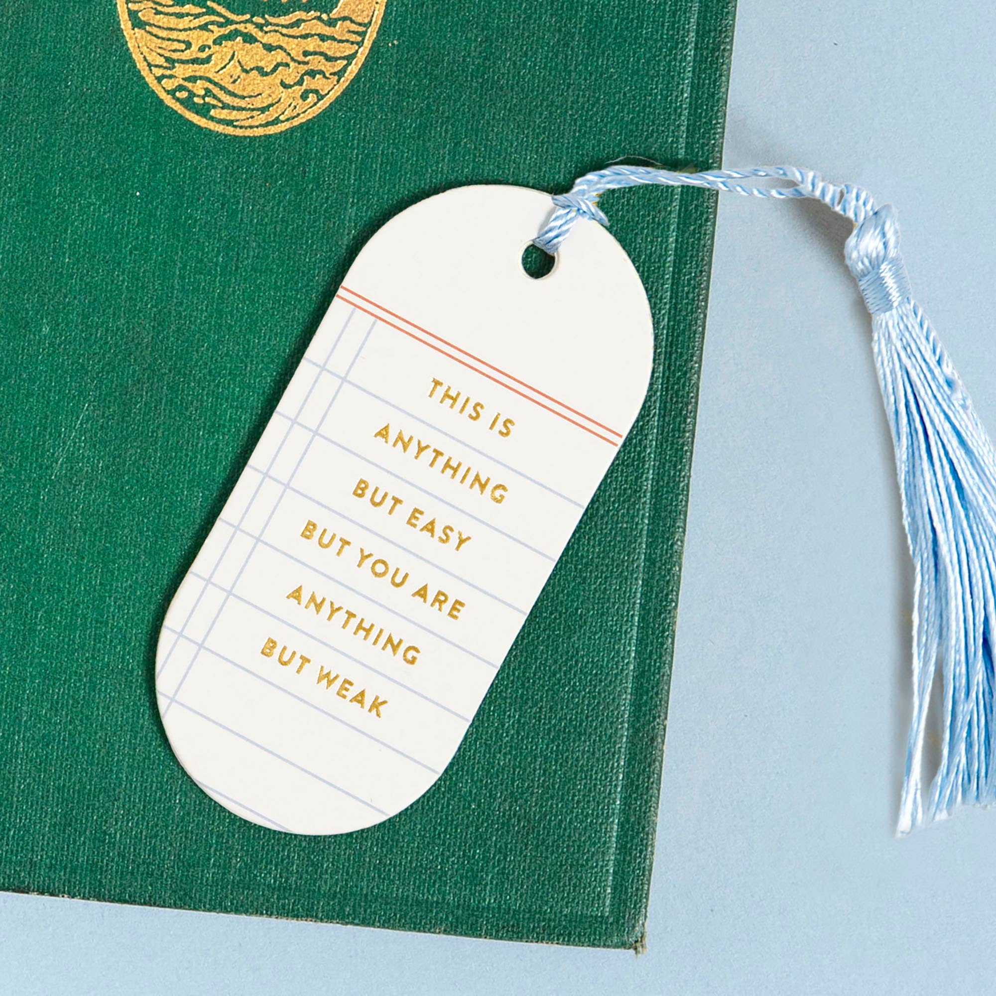 White motivational tag on a green book with a tassel