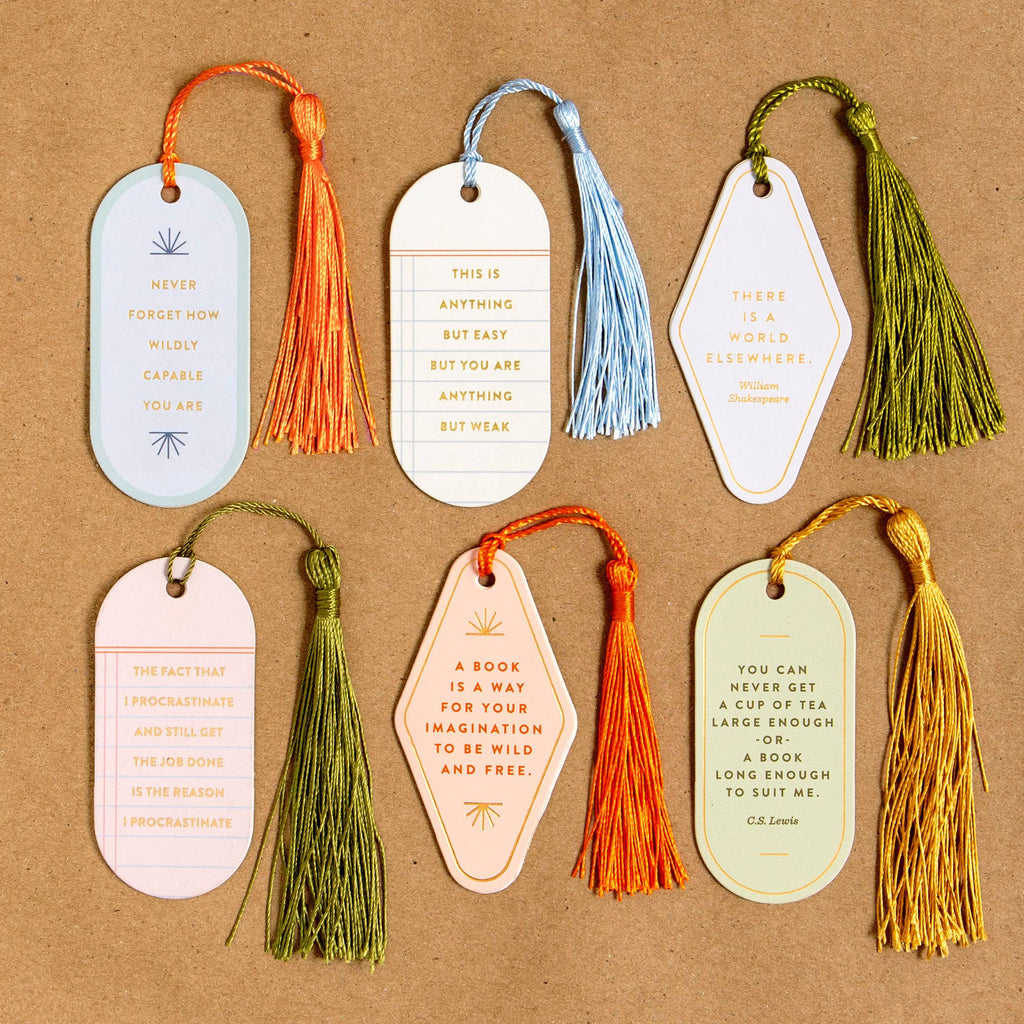 Set of six decorative bookmarks with tassels on a brown background