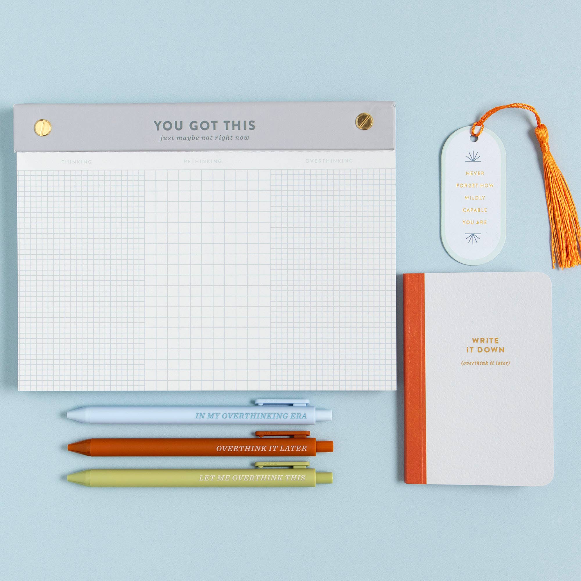 Notebook, pens, and bookmarks on a light blue background