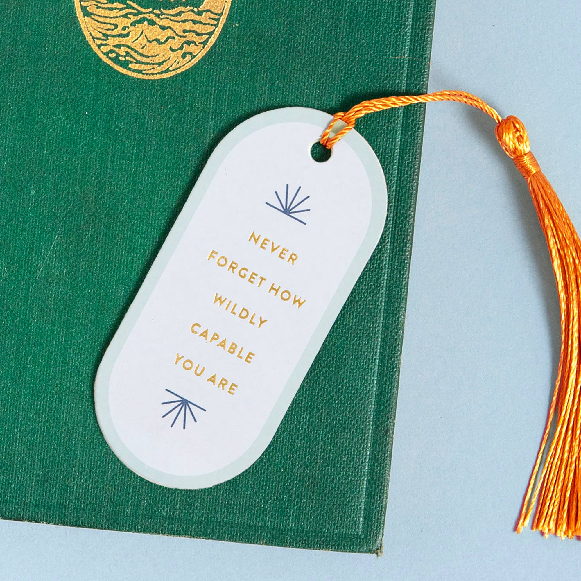 Motivational quote bookmark with tassel on a green book