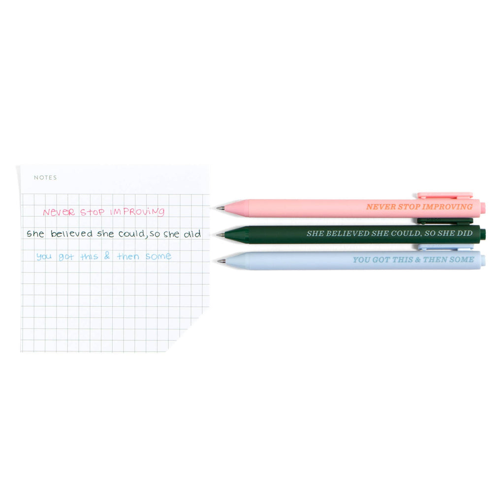 Motivational pens with quotes like 'Never Stop Improving' beside grid notebook for planners and journaling