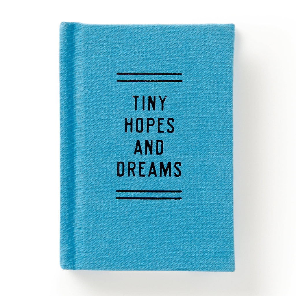 Blue fabric journal with 'Tiny Hopes and Dreams' text, ideal for cozy reads and intentional play.