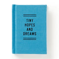 Blue fabric journal with 'Tiny Hopes and Dreams' text, ideal for cozy reads and intentional play.