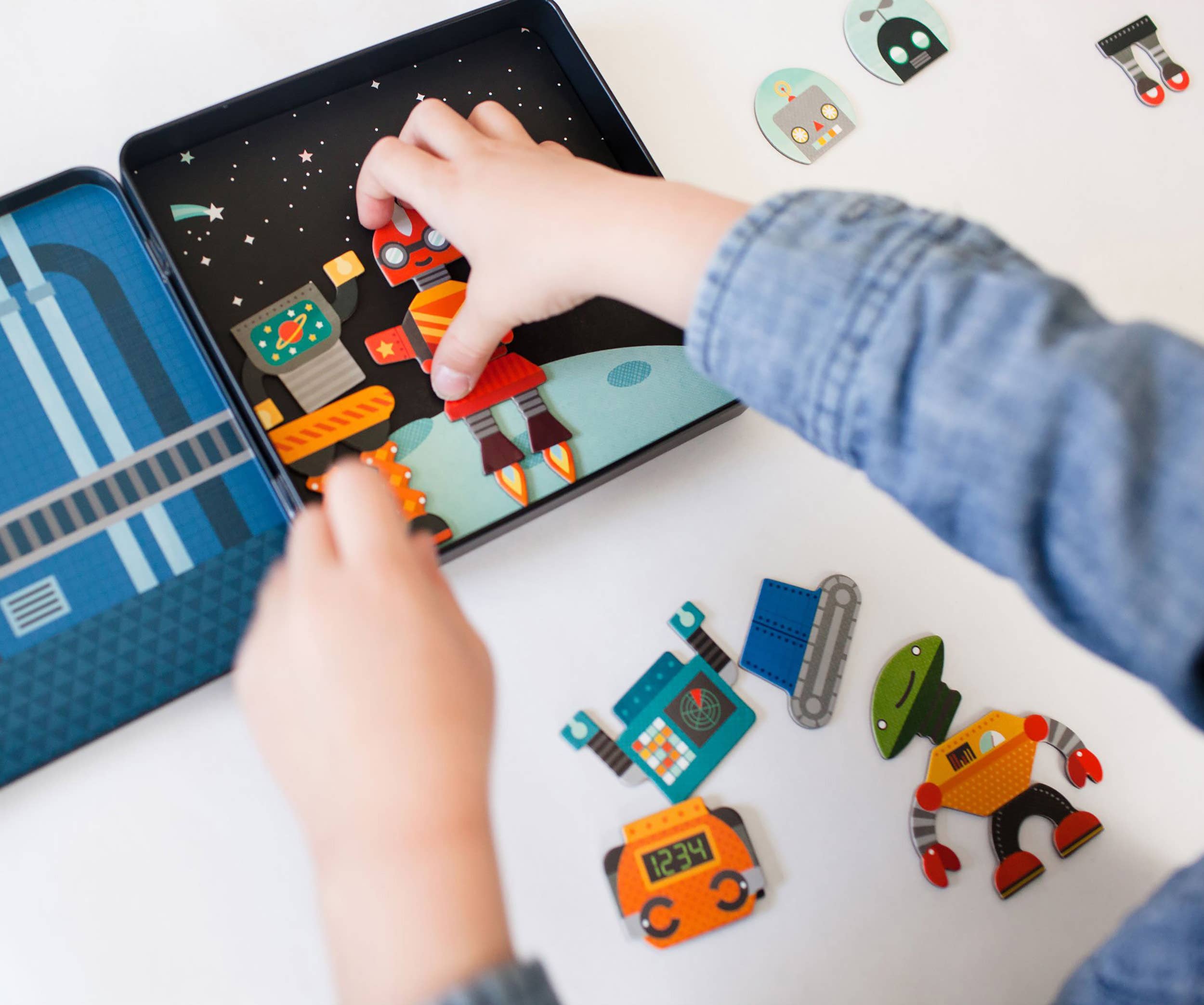 Child assembling colorful robot puzzle pieces on space-themed play mat, fostering creative play and learning.